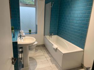 une salle de bain avec une baignoire, un lavabo et des toilettes dans l'établissement Tudors eSuites - Three Bedroom House - #16B, à Sedgley