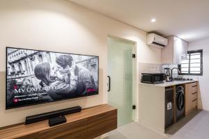 a large flat screen tv on a wall in a kitchen at Backyard in Lagos