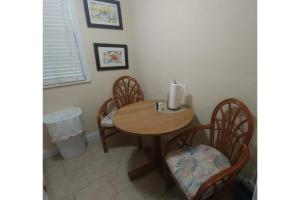 a dining room table with three chairs and a candle on it at Siesta Motor Inn By Townhouse Kennedy Space Center Titusville I 95 in Titusville