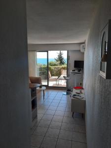 cocina y sala de estar con vistas a un patio en Appartement vue mer - Calme - Parking - Tennis - Piscine été, en Sète