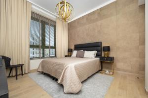 a bedroom with a large bed and a chandelier at Port de la Mer Luxury Sleeps 4Person in Dubai