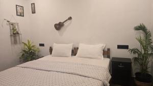 a bedroom with a bed with a guitar on the wall at Cascara Beach Resort in Varkala
