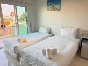 two beds in a room with a large window at Dancenter Bupatara Chiangmai in Chiang Mai