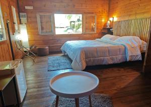 a bedroom with a bed and a table and a window at Agriturismo Kikajon in Linguaglossa