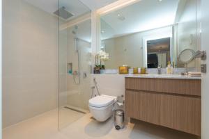 a bathroom with a toilet and a glass shower at Port de la Mer Luxury Sleeps 4Person in Dubai +26 photos