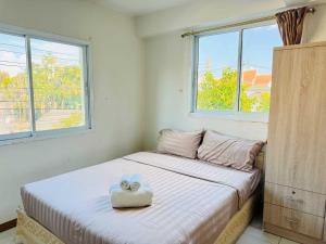 a bedroom with a bed with two towels on it at Dancenter Bupatara Chiangmai in Chiang Mai