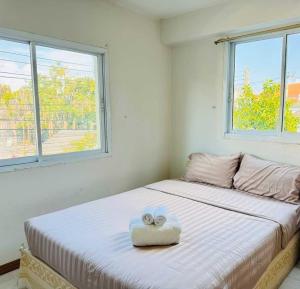 a bedroom with a bed with two towels on it at Dancenter Bupatara Chiangmai in Chiang Mai