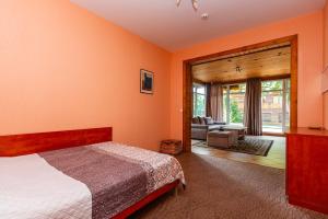 a bedroom with orange walls and a bed and a living room at Vila Elena in Palanga
