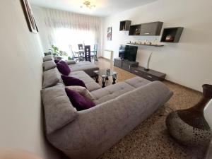 a living room with a large couch and a television at Piso amplio de 3 habitaciones, 2 baños, ascensor y parking in Burriana