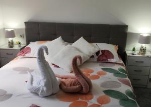 two stuffed swans are sitting on a bed at Apartment Mali Raj -Stunning Gacka River View-Peaceful Nature Escape in Otočac +71 photos
