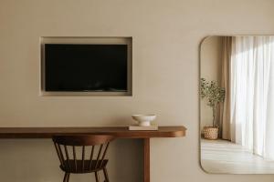 a room with a mirror and a television on the wall at AMÉNTE Mindful Suites in Plakias