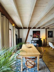 a living room with a wooden table and chairs at La Maison Rouge Au coeur de la ville. in Riquewihr