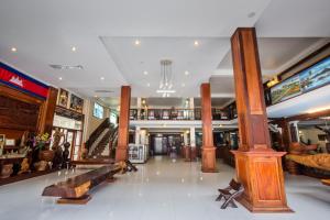 a lobby of a store with wooden columns and a staircase at Seng Hout Hotel in Battambang