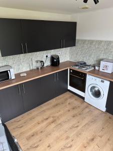 a kitchen with a stove and a washing machine at NKB Rooms in Carlton