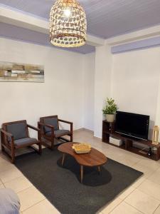 a living room with a table and chairs and a tv at Hermoso Depto en ELDORADO in Eldorado