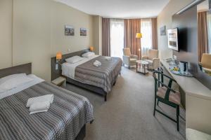 a hotel room with two beds and a living room at Corvin Hotel Budapest Corvin Wing in Budapest +53 photos