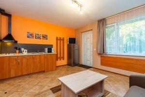 a kitchen with orange walls and a table in a room at Vila Elena in Palanga