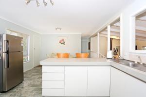 a kitchen with white cabinets and a stainless steel refrigerator at Amazing River House in North Yunderup