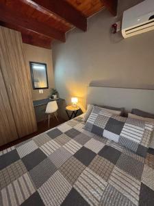 a bedroom with a bed with a checkered blanket at Kudu's Corner in Marloth Park +33 photos