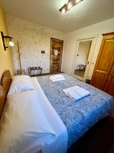 クティリアーノにあるAgriturismo Podere Paradisoのベッドとタオル2枚のある寝室