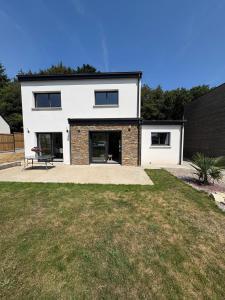 a white house with a bench in front of a yard at Maison neuve cosy à 20 min des plages #lorient #cosy in Pont-Scorff +19 photos