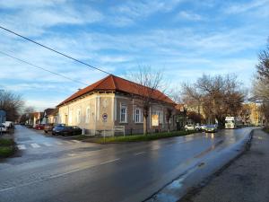 a building with a red roof on the side of a street at Georgi 2 in Subotica