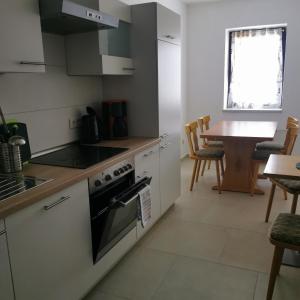 a kitchen with a stove top oven next to a table at Hotel mit Gasthof zur Post in Hochkirch