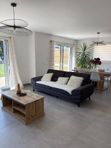 a living room with a couch and a table at Maison neuve cosy à 20 min des plages #lorient #cosy in Pont-Scorff