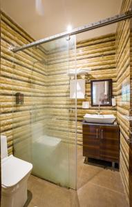 a bathroom with a shower and a toilet and a sink at Krishna Manor 3-BHK Farmhouse With Private Pool & Lush Garden Near Noida Expressway in Noida