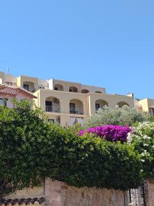 un grande edificio con dei fiori di fronte di Golf & Sea Residence Is Molas a Pula Altre 60 foto