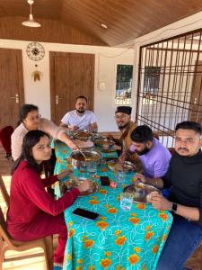 a group of people sitting around a table at Ejaar Homestay in Kāziranga