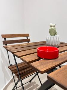 ein Holztisch mit einer roten Schale darauf in der Unterkunft Moonlight Rooms in Termini Imerese