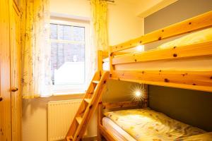 a bedroom with two bunk beds and a window at Südblick 1Whg 4 in Werdum