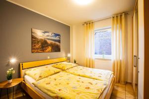 a bedroom with a bed with a yellow comforter and a window at Südblick 1Whg 4 in Werdum