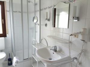 a white bathroom with a sink and a mirror at Baltique Fewo 1 in Glowe +2 photos