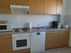 a kitchen with a white stove top oven next to a sink at Baltique Fewo 2 in Glowe +3 photos