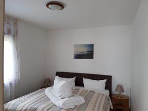 a bed with white sheets and pillows in a bedroom at Baltique Fewo 2 in Glowe