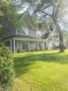 une grande maison blanche avec un arbre dans la cour dans l'établissement Chicago NorthShore Luxury Private Vacation Rental, à Wilmette 13 autres photos