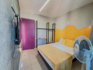 a room with a bed and a fan in it at Belô Hostel in Belo Horizonte