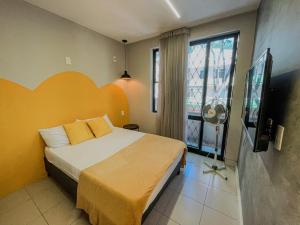Un dormitorio con una cama y un televisor de pantalla plana. en Belô Hostel, en Belo Horizonte