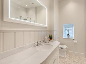 a white bathroom with a sink and a toilet at 2 Bed in Cockermouth 95716 in Broughton Moor