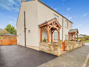 a large house with a stone building with a gate at 2 Bed in Cockermouth 95716 in Broughton Moor