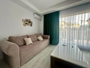 a living room with a couch and a large window at Terra Villa #Cosmopolis in Tunari