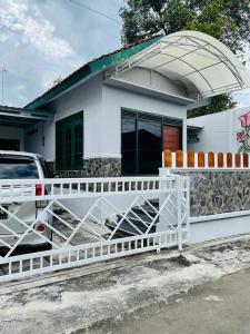 a white house with a white fence in front of it at Omah Eitan in Wonosari +1 photo