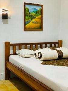 a white bed with a picture on the wall at Omah Eitan in Wonosari
