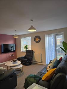 a living room with a couch and a chair at Gem Relax in Leighton Buzzard