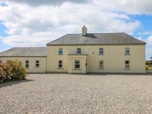 a large white house with a gravel driveway at Sanderling Lodge in Greenfield Cross Roads