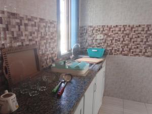 a kitchen counter with a sink and a window at Douha 2 in Al Maqārisah +8 photos