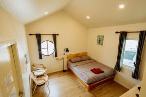 a bedroom with a bed and a chair in it at นารา พรีเมียม รีสอร์ท @ชัยนาท in Chai Nat