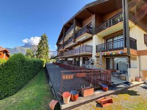 ein Apartmenthaus mit Topfpflanzen davor in der Unterkunft Le Saint Bernard - T2 Terrasse Vue Mont Joli 42m2 in Saint-Gervais-les-Bains
